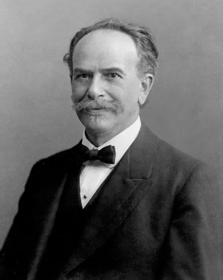 Portrait of Franz Boas in 1915. Image is black and white. Boas sits upright and smiles without showing his teeth.
