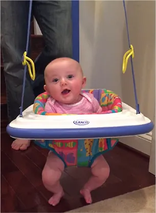 A photo of a baby in a hanging bouncer.