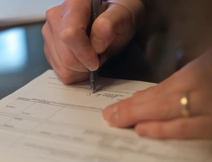 A person is signing a document.