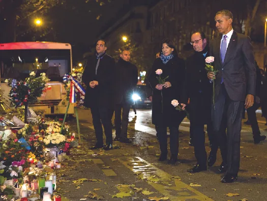 An image of Barack Obama, François Hollande, and Anne Hidalgo laying roses at a makeshift memorial.