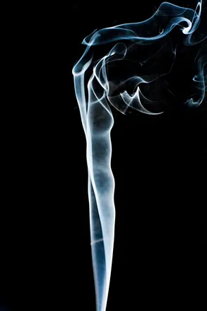 Ilustracja przedstawia zdjęcie dymu, który unosi się równomiernie na dole, a na górze duża prędkość powoduje powstawanie wirów.
