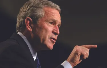An image of George W. Bush in profile, pointing his finger to the right.