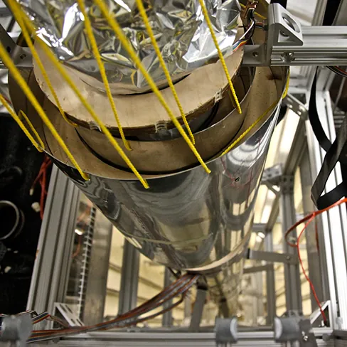 A photograph shows an atomic clock. The image is taken looking downward from the top of an atomic clock.