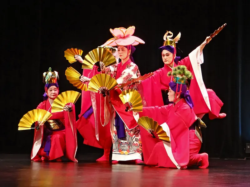 Four dancers perform a traditional Okinawan dance.