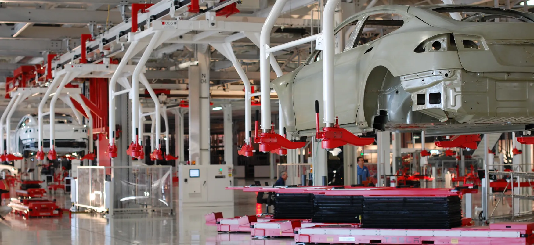Cars are put together on the assembly line at a Tesla factory.