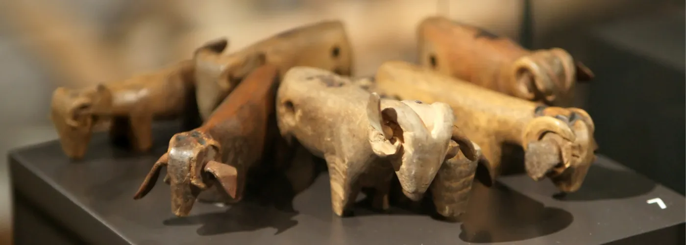 Wooden tally sticks in the shape of sheep are displayed in a museum.