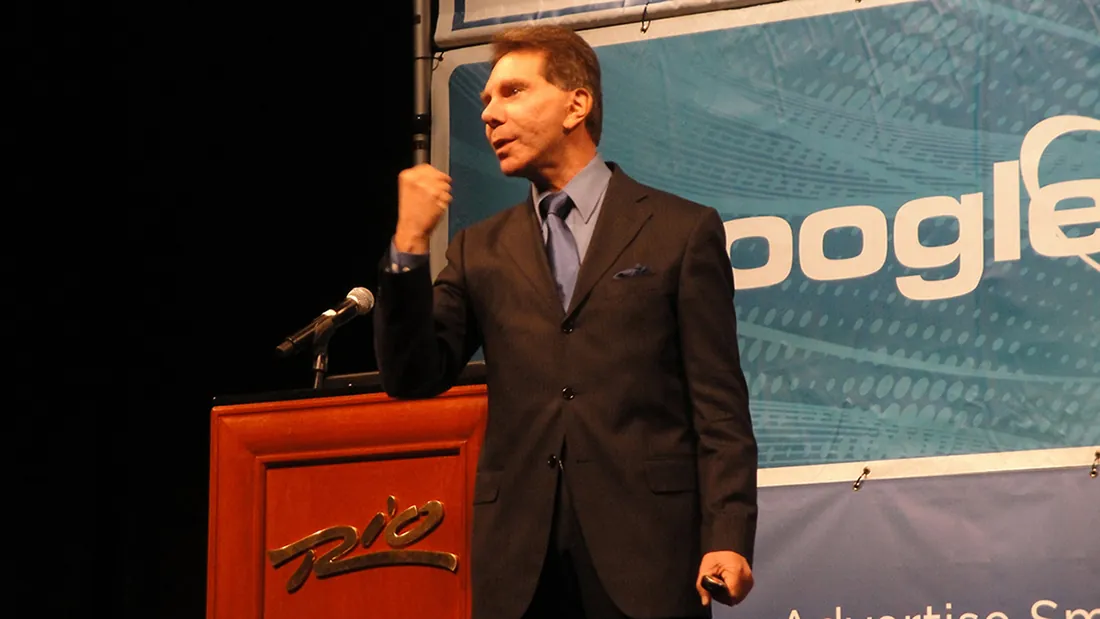 A photo shows the American psychologist Robert Cialdini clenching his fist as he delivers a speech.