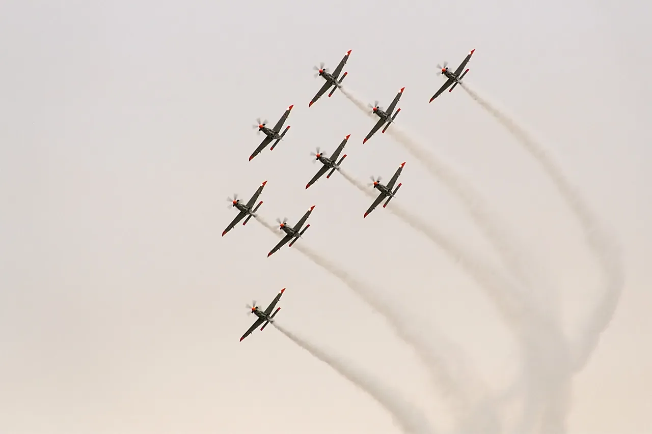 Zdjęcie dziewięciu myśliwców lecących w formacji.