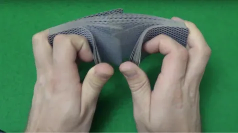La foto muestra la mano de una persona barajando un mazo de cartas.