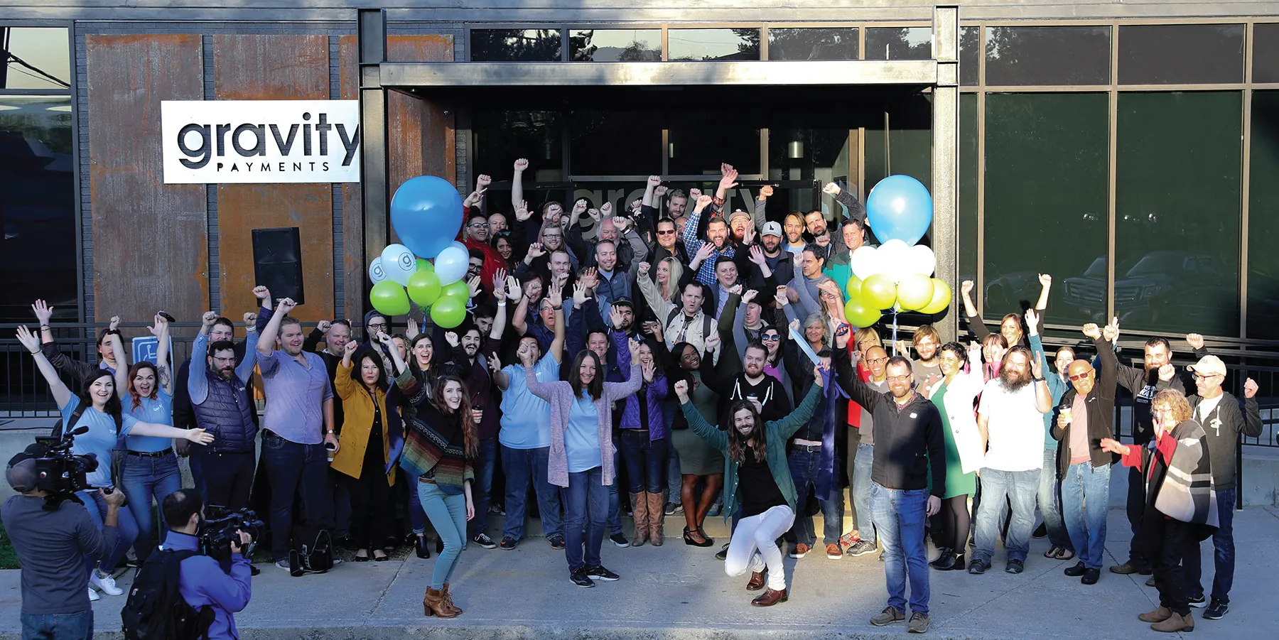 Photo of a crowd of people in front of a Gravity Payments banner.