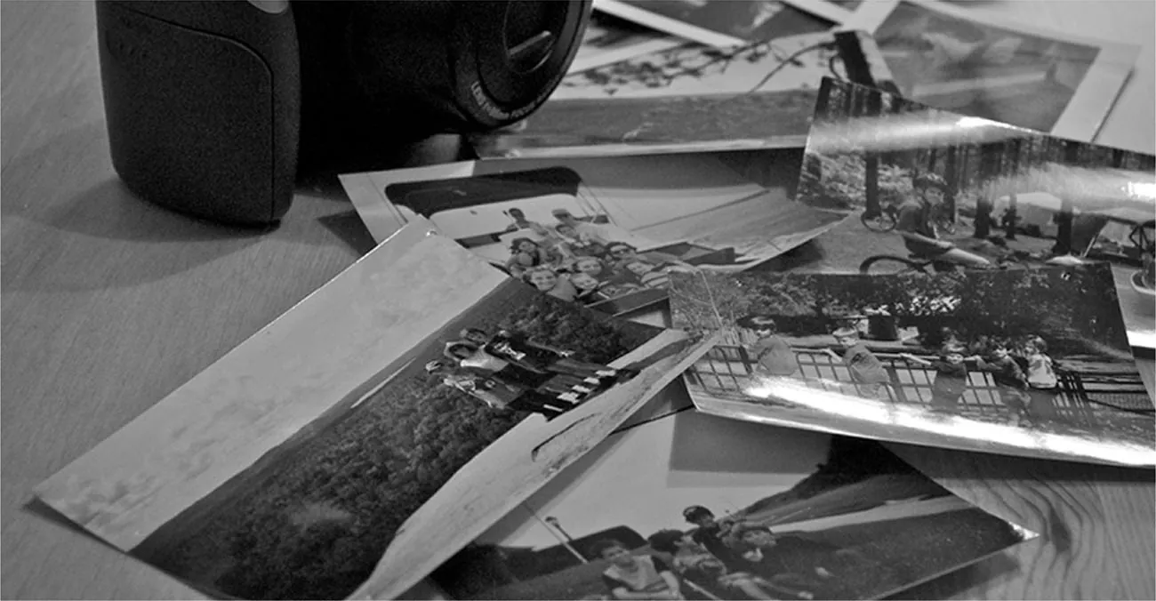 A photograph shows a camera and a pile of photographs.