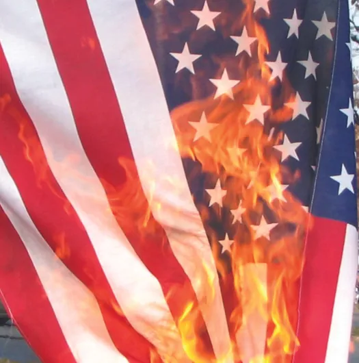 A photo of an American flag. The flag is on fire.