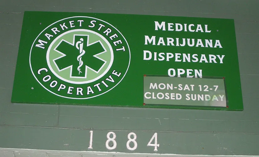 Photo of a sign for a medical marijuana dispensary showing that the business is open