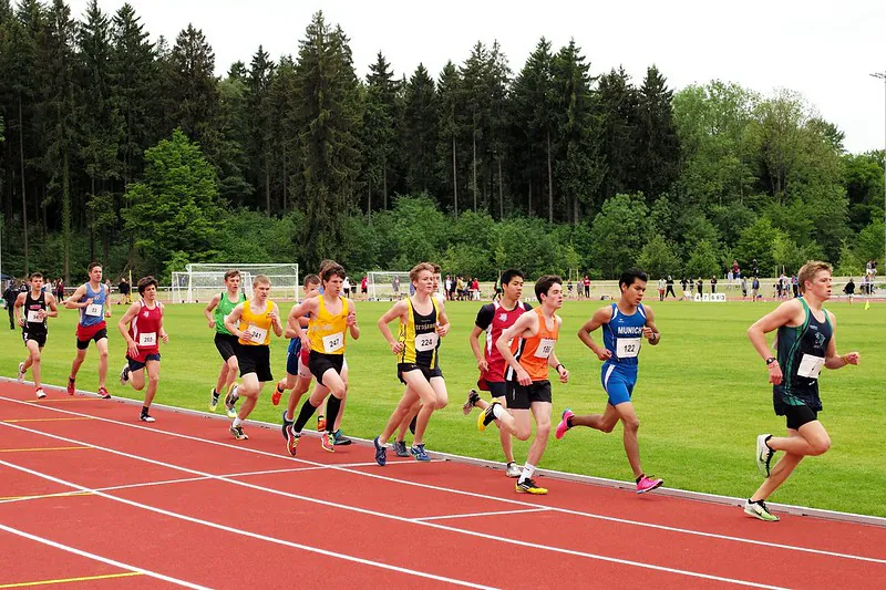 Young athletes run on a race track during a track and field event.