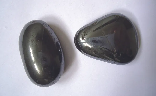 Se muestran dos piedras negras redondeadas y lisas.