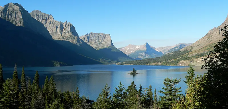 Serene Saint Mary Lake and Wild Goose Island are surrounded by mountains and trees.