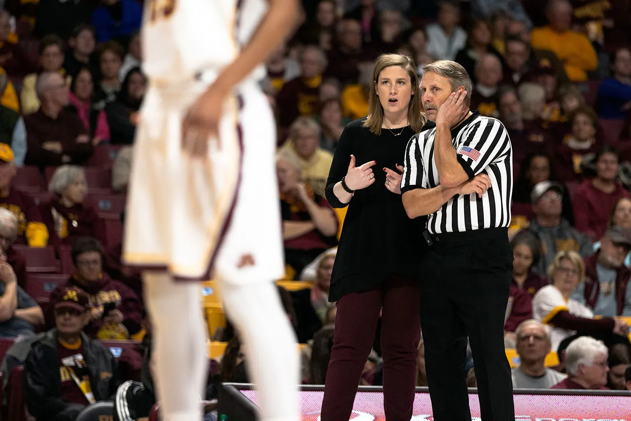 A photo shows Minnesota Gophers coach, Lindsay Whalen talking to a referee during a University of Minnesota Gophers game against Cornell University.