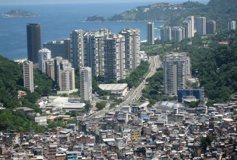 This photo is of a city with large high rises in the background and a slum in the foreground.