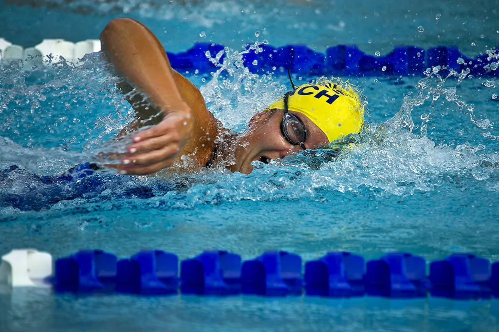 A swimmer in a pool doing the backstroke.