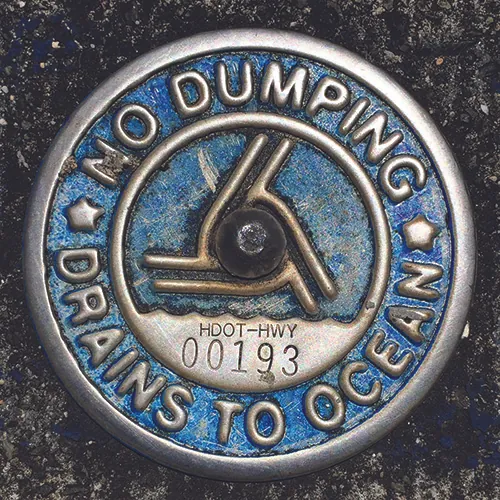 A sign that reads “No Dumping, Drains to Ocean”.