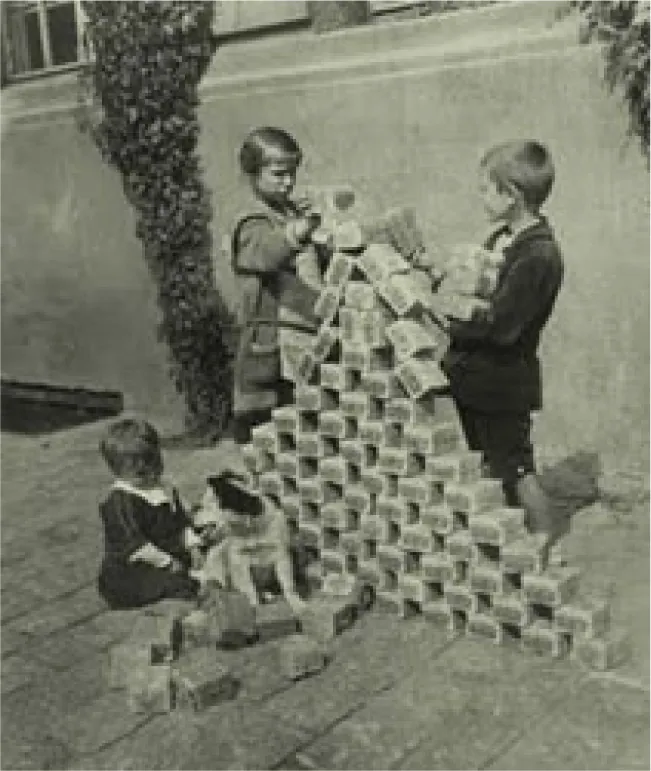 Three children play with stacks of banknotes. Two of the children use them to build a pyramid almost as tall as themselves. The third child sits with a dog nearby among a pile of banknotes.