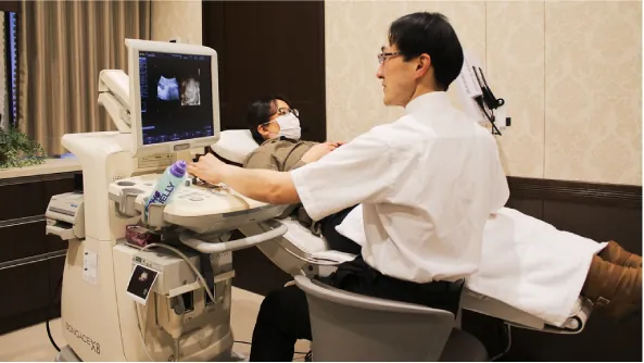 A technician uses ultrasound equipment to examine a pregnant woman's belly.