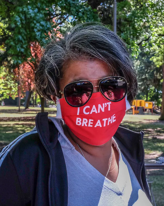 A person wears a red mask over the nose and mouth that reads, “I can’t breathe.”