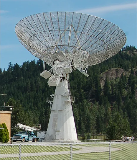 Photograph of a large dish antenna on top of a conical pillar.