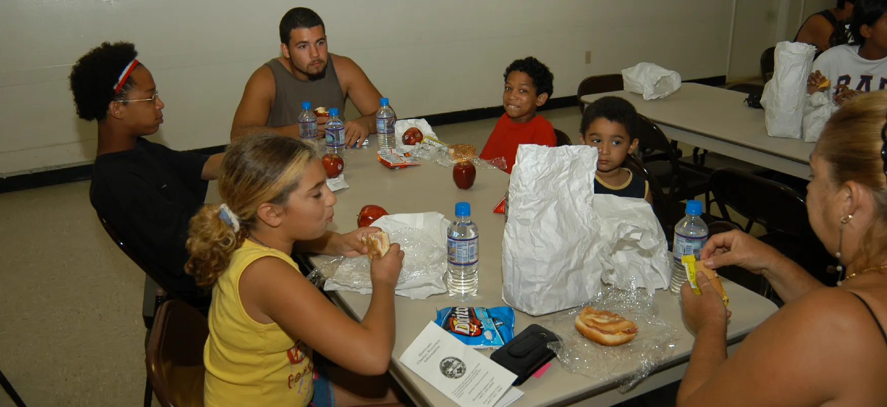 An evacuated Floridian family eats a makeshift meal at a shelter set up during Hurricane Charley in 2004.