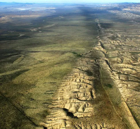 Image of the San Andreas Fault in California. In this aerial photo we see the relatively straight trench-like fault line running off to the horizon.
