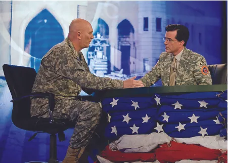 An image of Stephen Colbert and Ray Odierno seated on opposite sides of a table, facing each other.