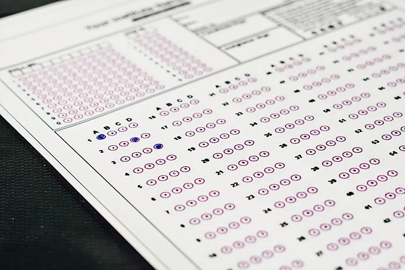 A standardized test form with bubbles for options A, B, C, and D is shown. The answer choices for the first three questions are filled in.