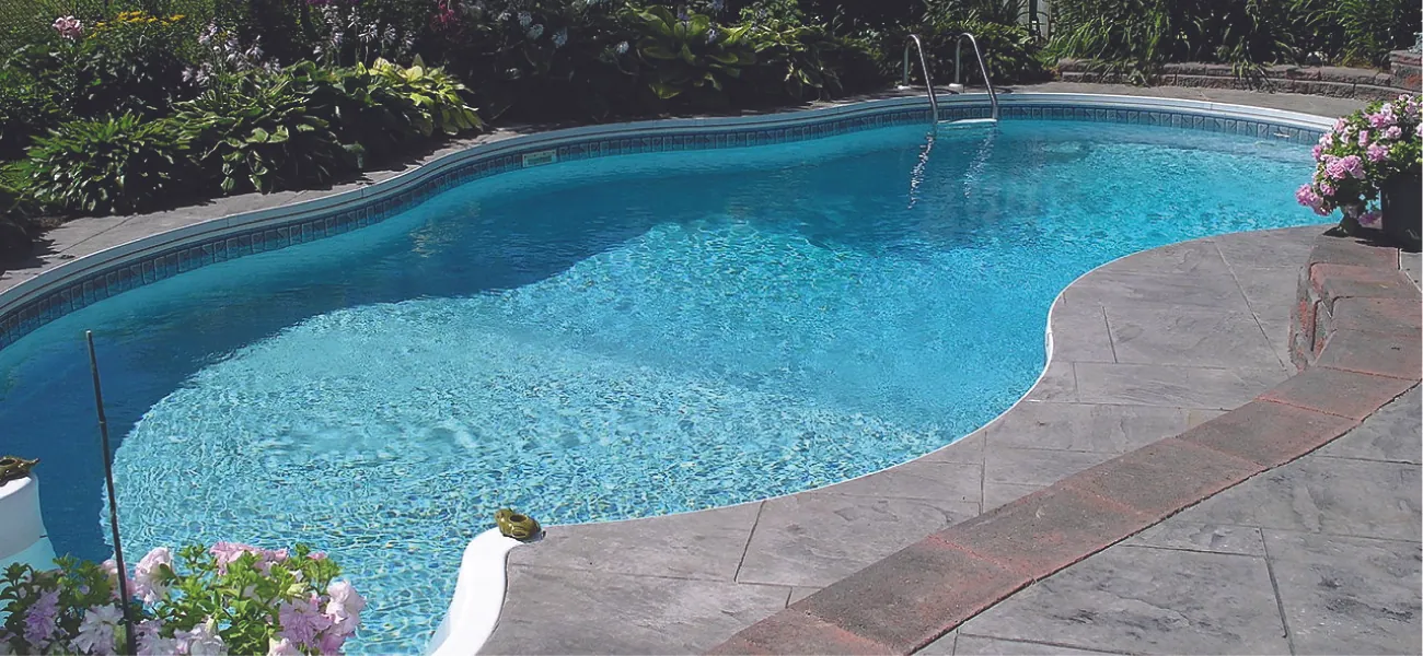 This figure shows a swimming pool that is full of water and surrounded by a concrete patio.