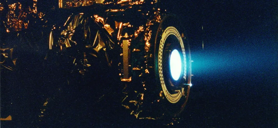 Zdjęcie pokazuje ksenonowy silnik jonowy i niebieską poświatę emitowaną z niego.