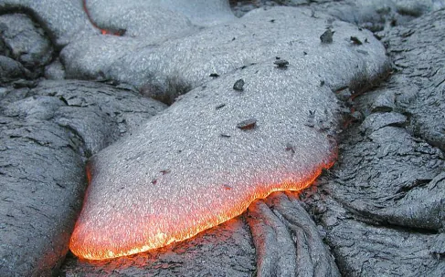 Image of a Lava Flow from a Basaltic Eruption. The leading edge of the flow is red-hot, while the surface behind has cooled to almost black