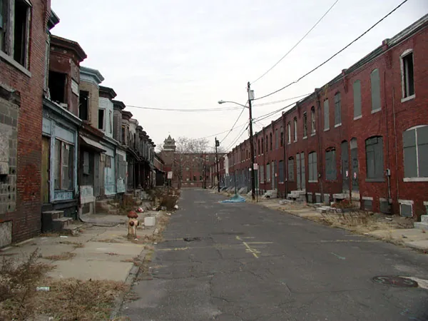 A block of run-down, dirty rowhouses is shown.