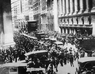 A photograph shows large crowds of people on Wall Street.