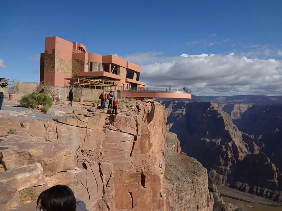 This figure is a picture of the Grand Canyon skywalk. It is a building at the edge of the canyon with a walkway extending out over the canyon