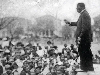 A photograph shows Booker T. Washington speaking and gesturing before a large crowd.