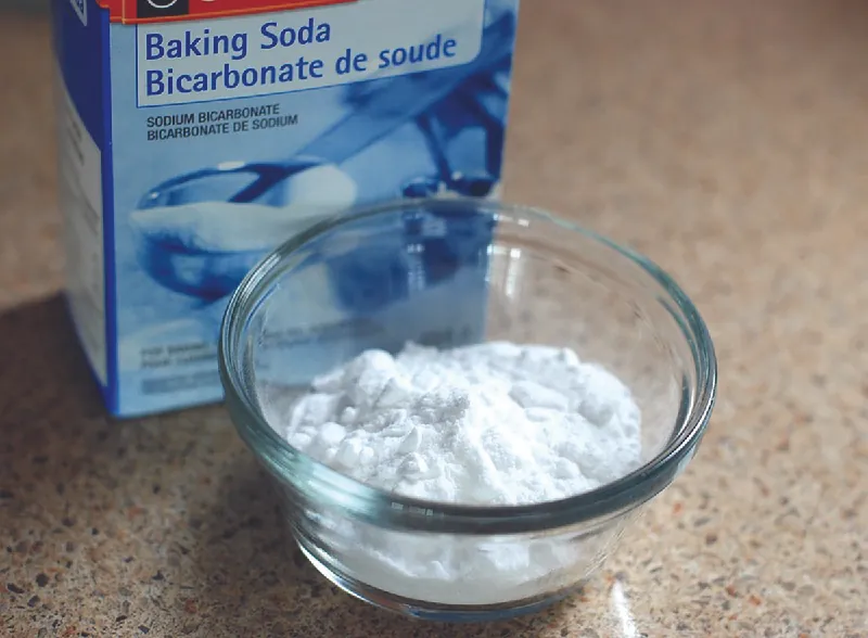 A photo of a box of baking soda, with some of the baking soda in a clear bowl.