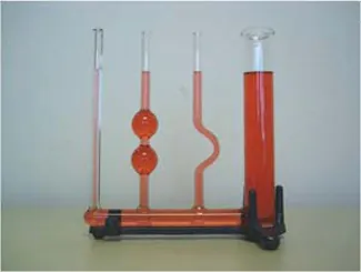 Foto de unos recipientes de vidrio de diferente forma conectados por un tubo de vidrio en el fondo y llenos de fluido rojo. El fluido está a la misma altura en los diferentes recipientes de vidrio.