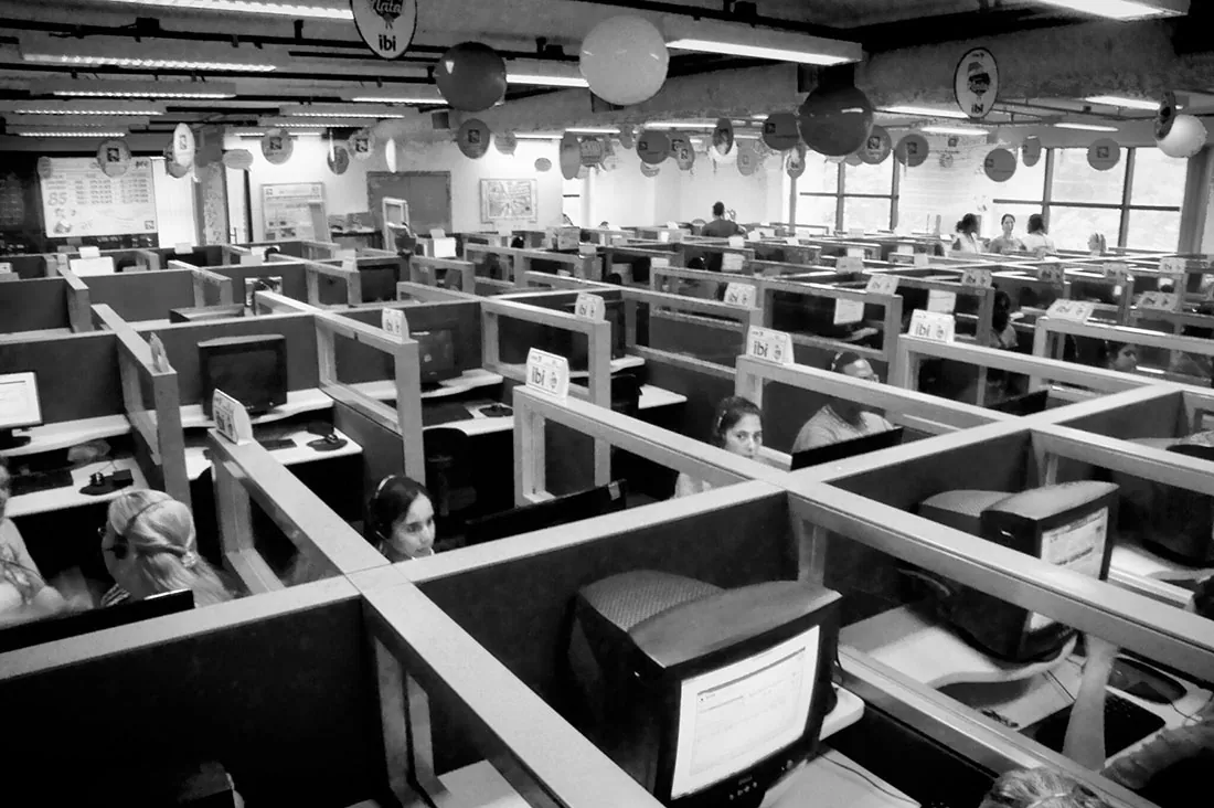 Many people at workstations in a call center are shown here.