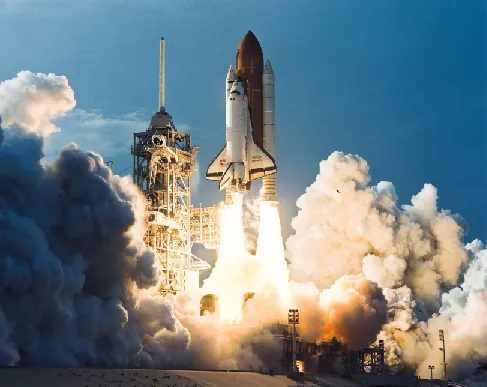 Photograph of the Space Shuttle Discovery at liftoff.