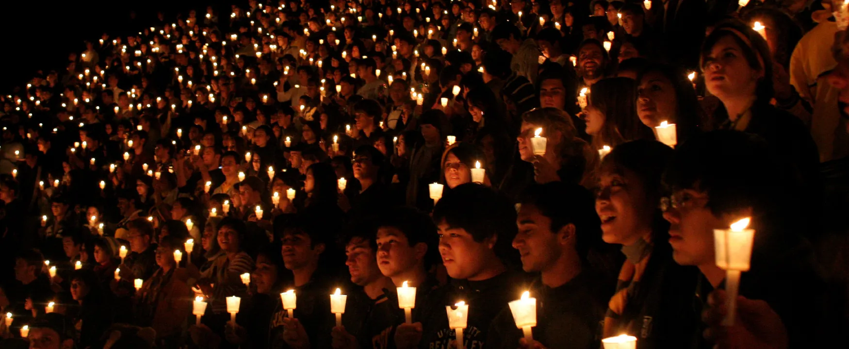 A photo shows a massive group of young girls and boys holding candles at a vigil.