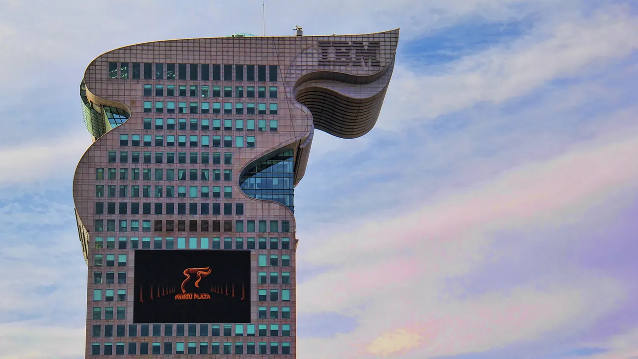 A photo shows a close-up of the Dragon Building, I B M’s headquarters based in China, against a clear blue sky.