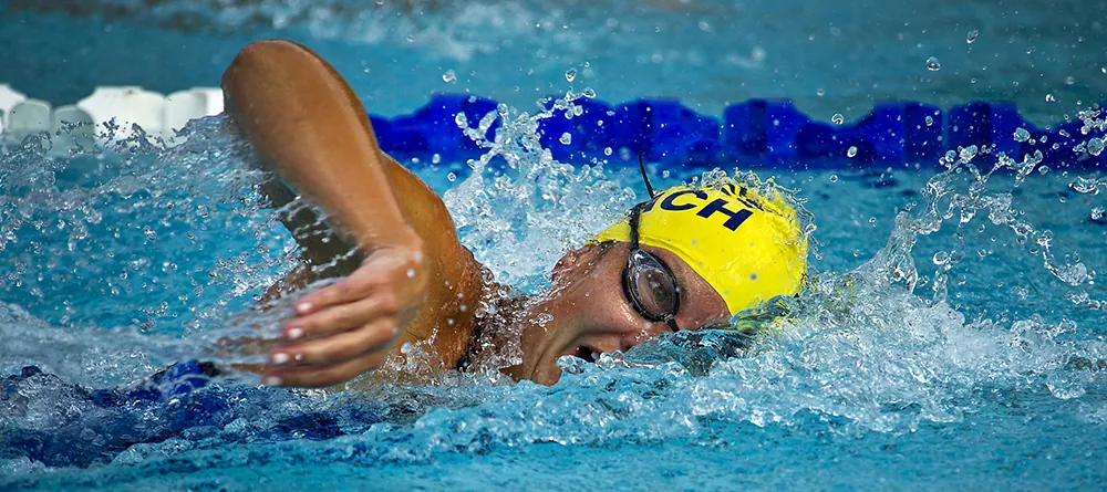 A swimmer in a pool doing the backstroke.