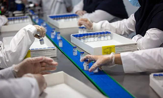 A photo of a group of scientists processing vials of vaccine.