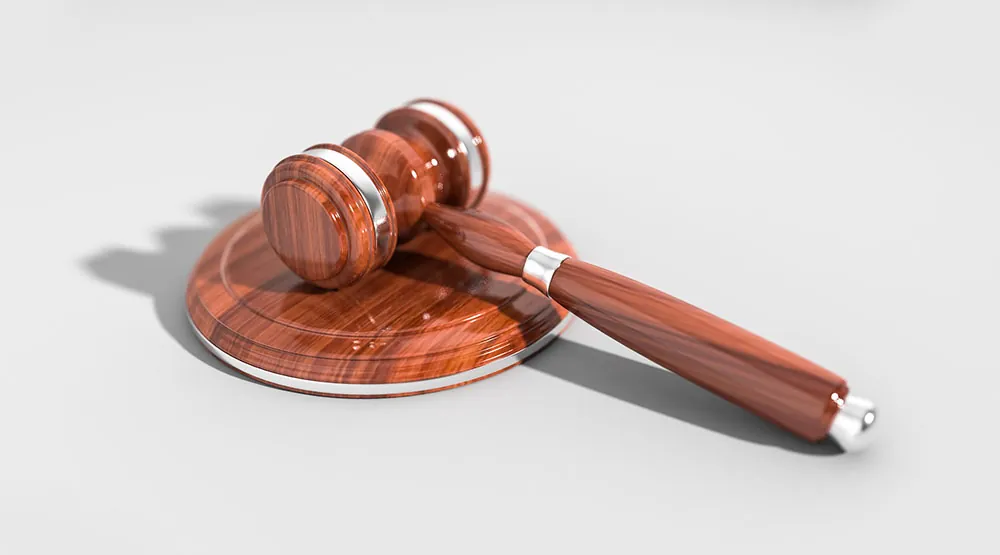 A photo of a gavel, United States flag and book to represent the U.S. justice system.