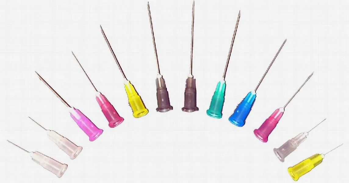 A photograph shows a variety of needle gauges and lengths arranged in a semicircle. Each needle has a different colored piece of plastic tubing at its base.