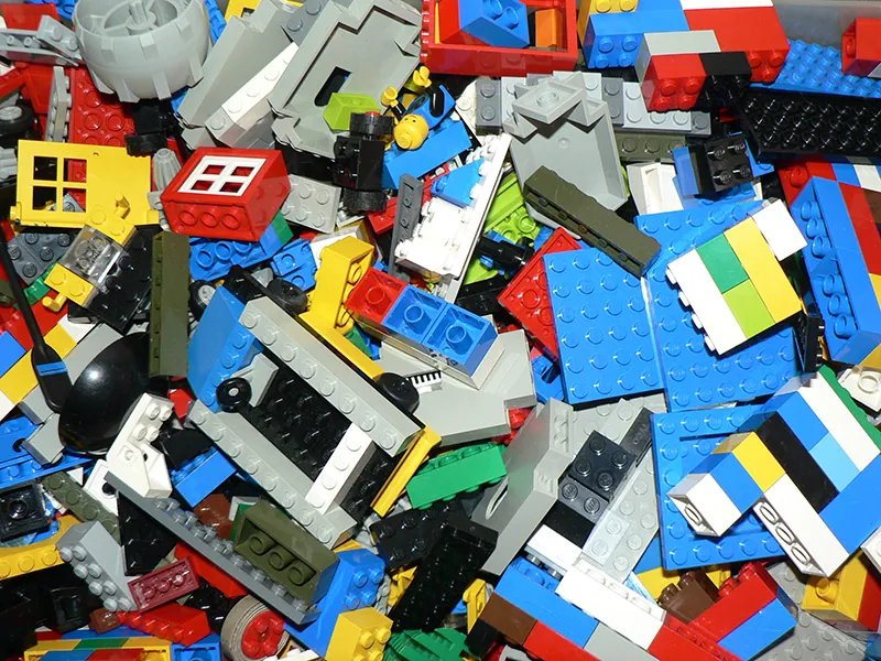 Na obrazku widzimy porozrzucane klocki LEGO o różnych rozmiarach.